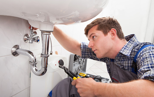 man fixing apartment sink plumbing